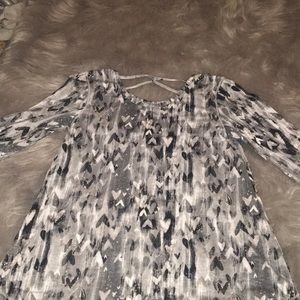 Gray black and white shirt and a cross in the back